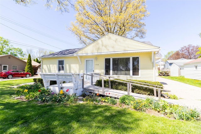 bungalow-style home with a front lawn and a wooden deck