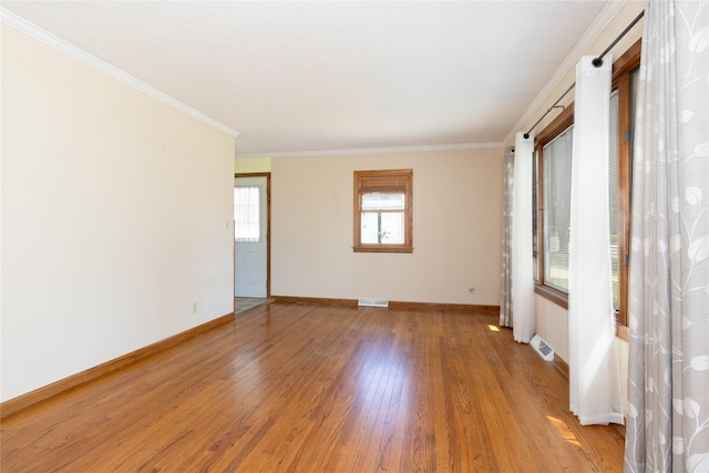 unfurnished room with light wood-type flooring, baseboards, and crown molding
