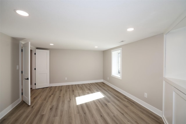 interior space featuring light wood-type flooring, baseboards, and recessed lighting