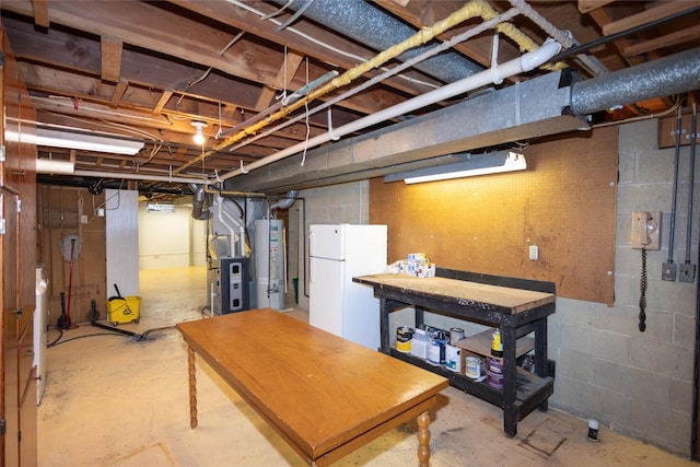 unfinished basement featuring freestanding refrigerator, heating unit, and water heater