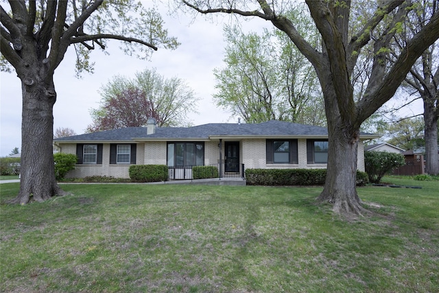 single story home featuring a front yard and brick siding