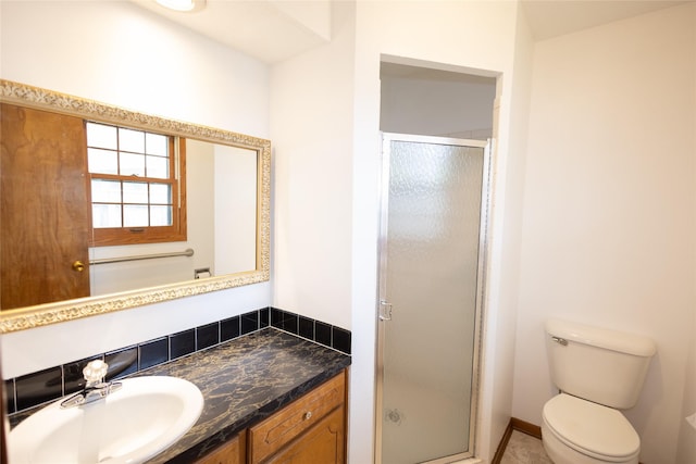bathroom featuring toilet, a shower stall, and vanity