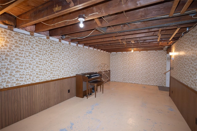 unfinished basement with wooden walls, wallpapered walls, and a wainscoted wall