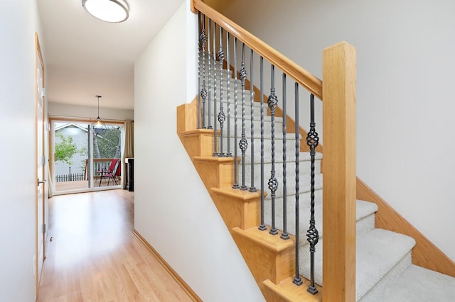 stairway featuring baseboards and wood finished floors