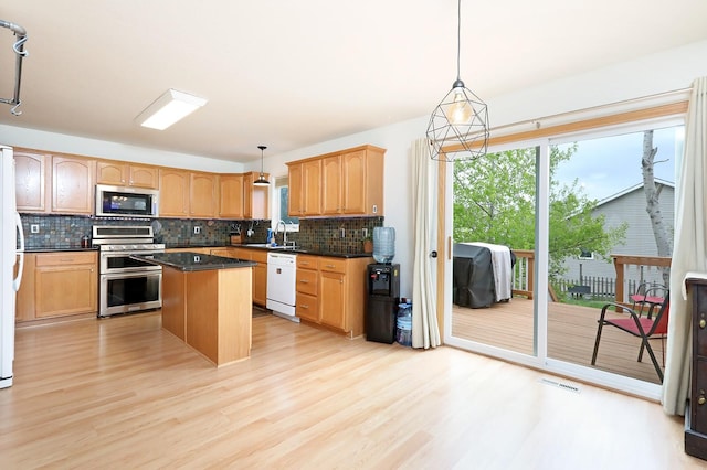 kitchen featuring a center island, decorative backsplash, appliances with stainless steel finishes, and dark countertops