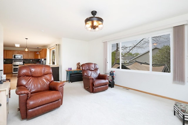 living area featuring baseboards, light carpet, and visible vents