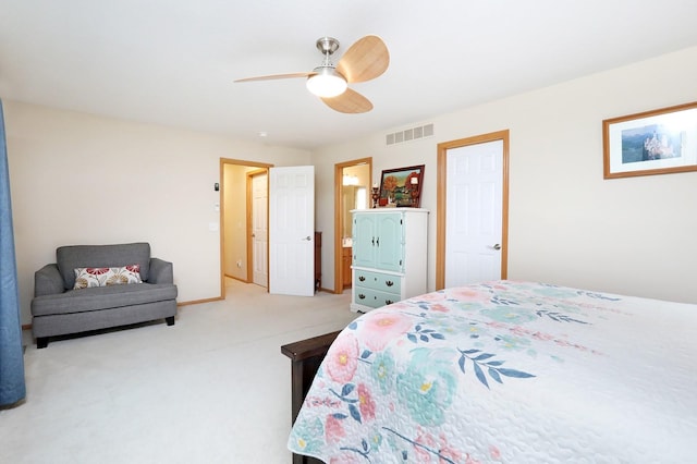 bedroom with light colored carpet, a ceiling fan, visible vents, and ensuite bathroom