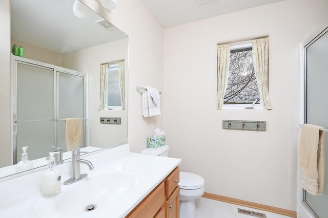bathroom featuring an enclosed shower, vanity, toilet, and visible vents