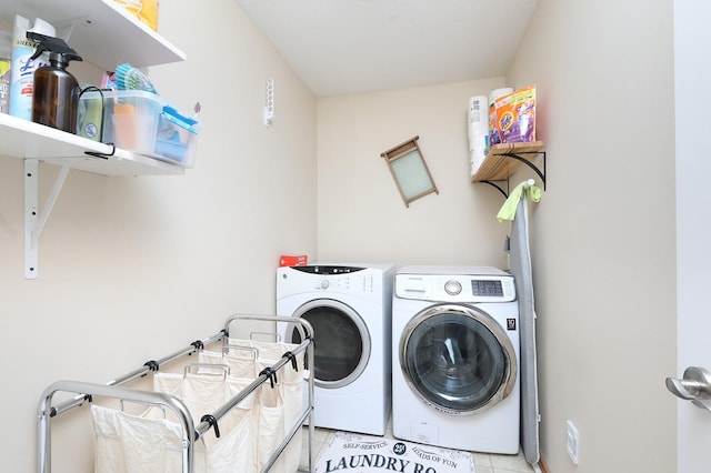 laundry area with independent washer and dryer, light tile patterned flooring, and laundry area