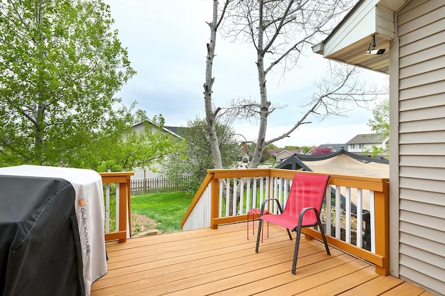 wooden deck featuring fence and a grill