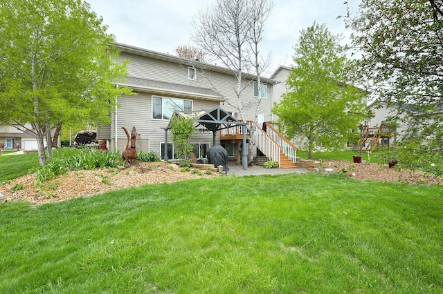 rear view of house with stairs, a yard, and a deck