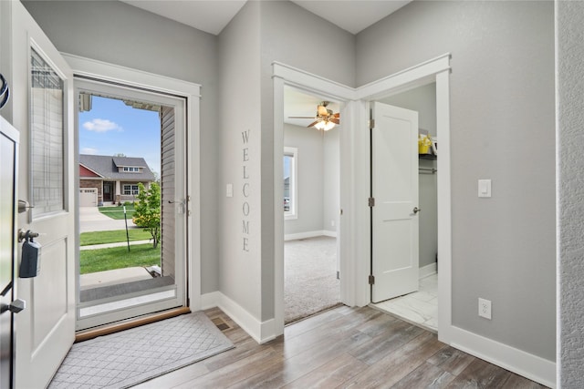 entrance foyer featuring baseboards, ceiling fan, a wealth of natural light, and wood finished floors