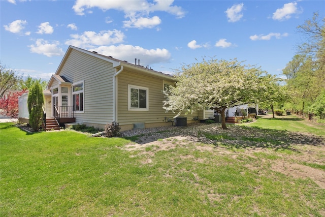 exterior space featuring a yard, a deck, and central AC unit