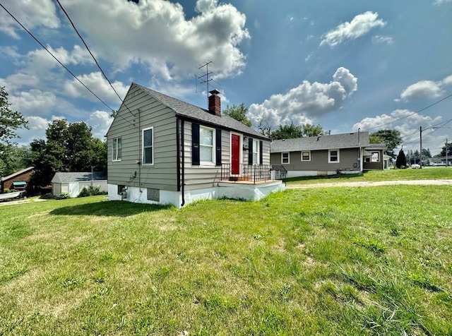 view of front facade featuring a chimney and a front yard