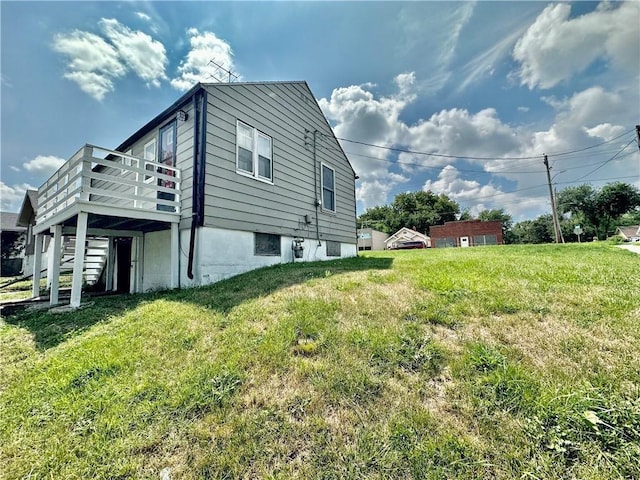 view of side of home with a yard, a wooden deck, and stairs