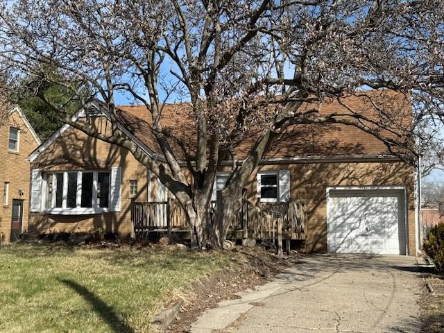 view of front facade featuring a garage, driveway, and a front yard