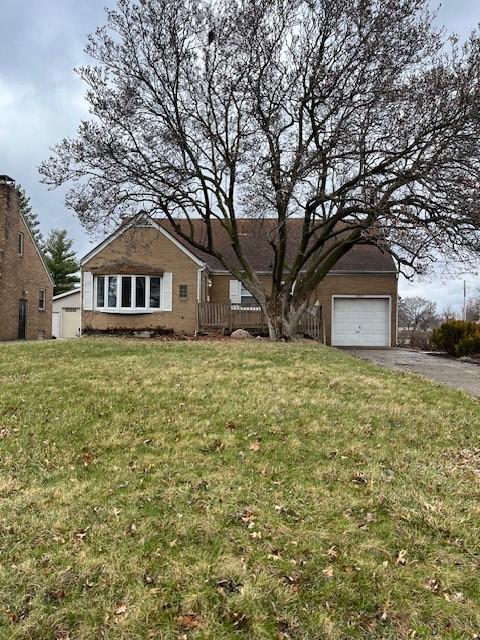single story home with a garage, aphalt driveway, and a front yard