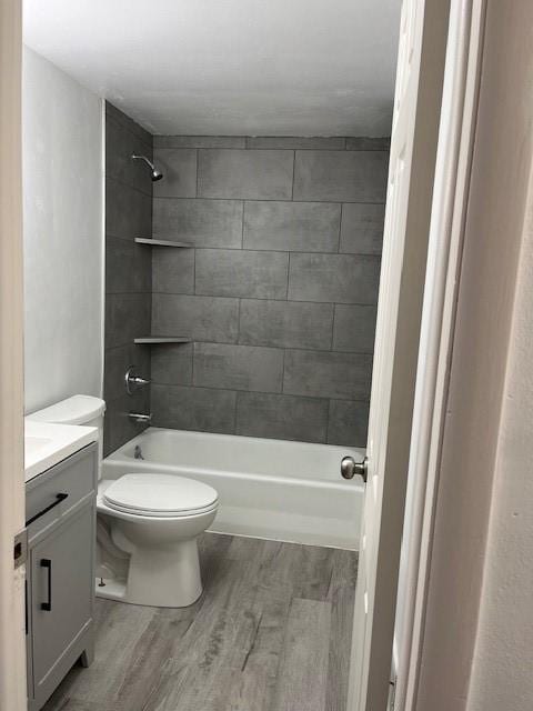 bathroom with vanity, shower / bathing tub combination, toilet, and wood finished floors