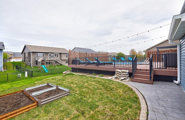 1009 NW Orchard Dr, Ankeny, IA 50023 - view of yard featuring a garden, a residential view, a wooden deck, fence, and a playground