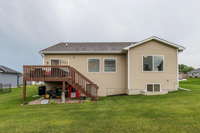 rear view of house featuring a lawn, a deck, stairs, and roof with shingles