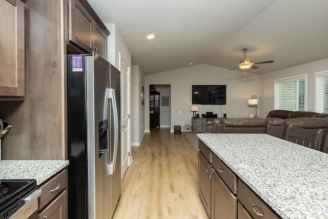 kitchen featuring ceiling fan, stainless steel refrigerator with ice dispenser, light stone countertops, lofted ceiling, and light wood-style flooring