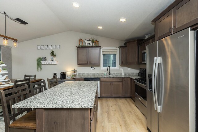 2500 N 7th Ave E, Newton, IA 50208 - kitchen with appliances with stainless steel finishes, lofted ceiling, light wood-style flooring, dark brown cabinetry, and a kitchen island