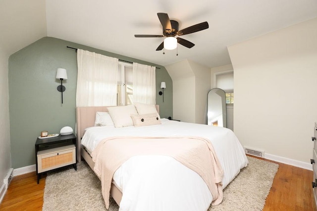 bedroom with visible vents, a ceiling fan, lofted ceiling, and wood finished floors