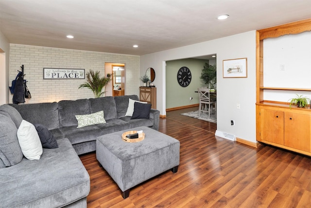 living room with brick wall, recessed lighting, baseboards, wood finished floors, and visible vents