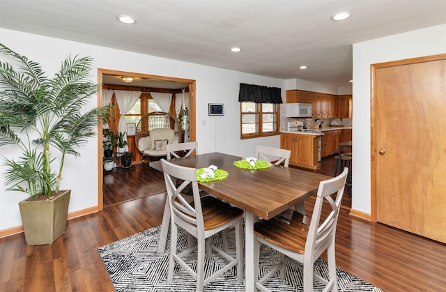 dining space with baseboards, dark wood-type flooring, recessed lighting, and a wealth of natural light