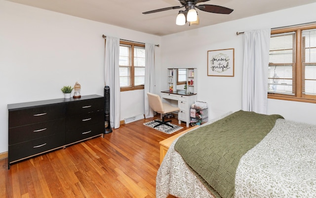 bedroom with a ceiling fan, light wood finished floors, and visible vents
