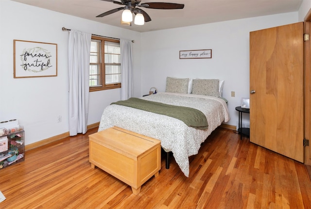 bedroom featuring baseboards, light wood finished floors, and ceiling fan