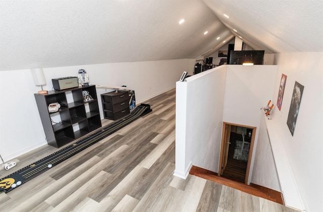 interior space featuring vaulted ceiling, recessed lighting, and wood finished floors