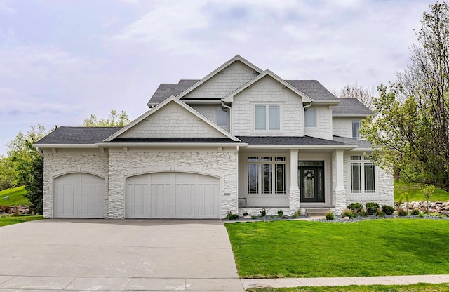 craftsman inspired home with roof with shingles, a garage, a front lawn, concrete driveway, and stone siding