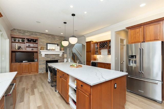 kitchen with light wood-type flooring, open shelves, stainless steel appliances, and brown cabinets