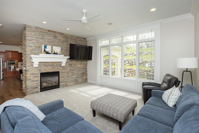 living area featuring ornamental molding, a stone fireplace, recessed lighting, and ceiling fan