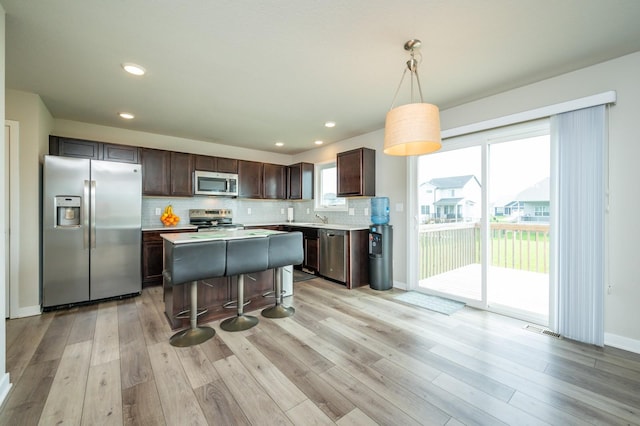 kitchen featuring dark brown cabinets, appliances with stainless steel finishes, visible vents, and light wood-type flooring