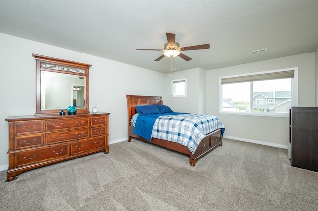 carpeted bedroom with baseboards, ceiling fan, and visible vents