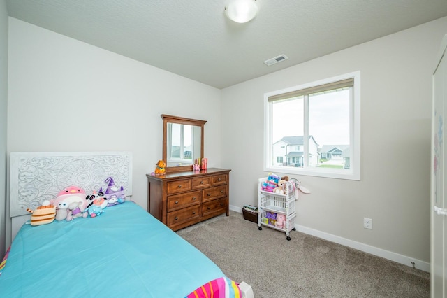 bedroom with visible vents, baseboards, and light carpet