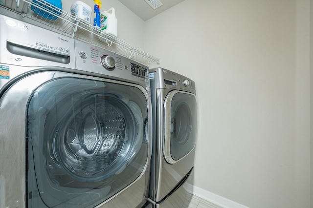 laundry room with baseboards, laundry area, visible vents, and washer and clothes dryer