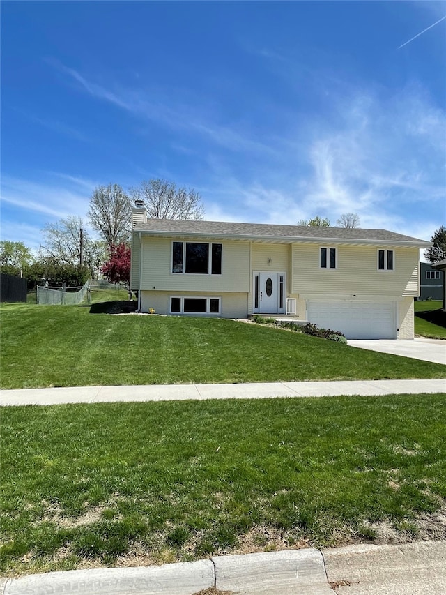 view of front of home featuring a chimney, an attached garage, driveway, and a front yard