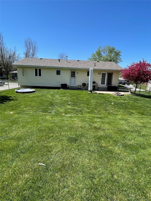rear view of property with a lawn, cooling unit, and a patio area