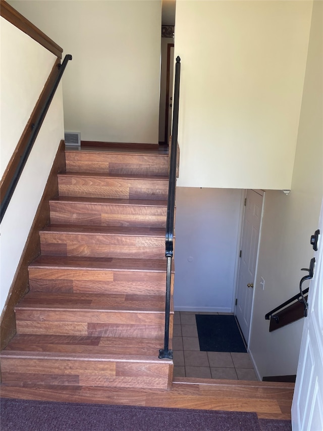 stairs featuring baseboards, tile patterned flooring, and visible vents