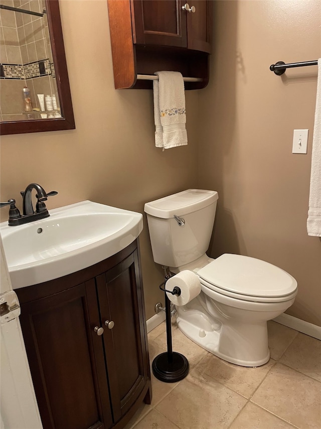 bathroom with vanity, baseboards, tile patterned floors, and toilet