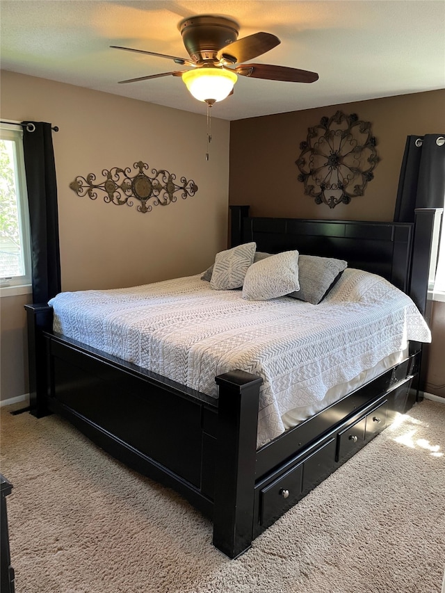 carpeted bedroom with baseboards and a ceiling fan