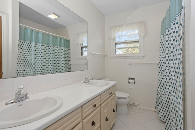 full bath featuring a sink, tile patterned floors, toilet, and double vanity