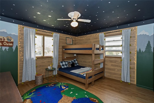 bedroom with multiple windows and wood finished floors