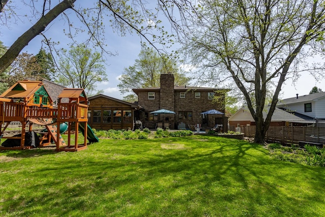 view of yard featuring a patio area, a playground, and fence