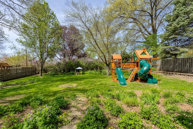 view of playground with a lawn and a fenced backyard