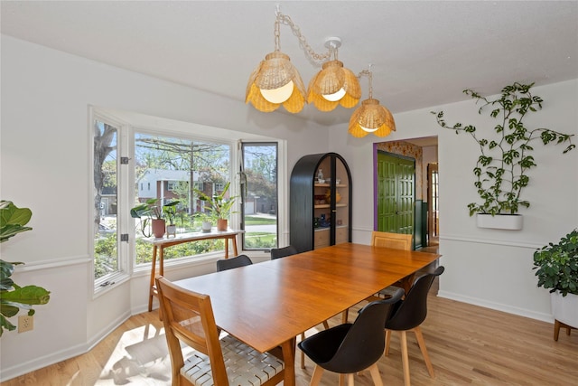 dining space with light wood-style floors and baseboards
