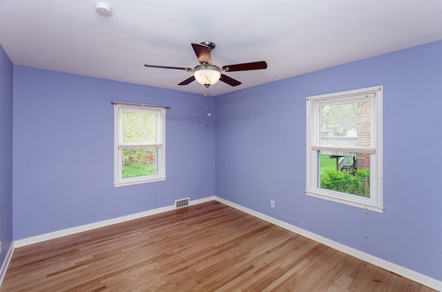 unfurnished room featuring visible vents, light wood-style floors, ceiling fan, and baseboards